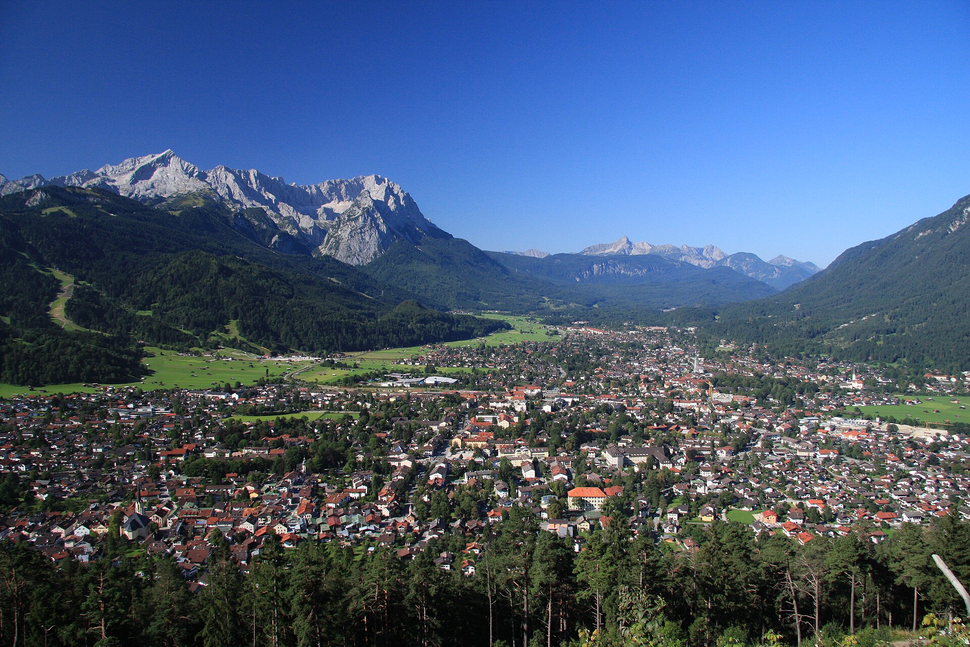 Garmisch-Partenkirchen with the mountains Alpspitze , Zugspitze and Daniel in the background.