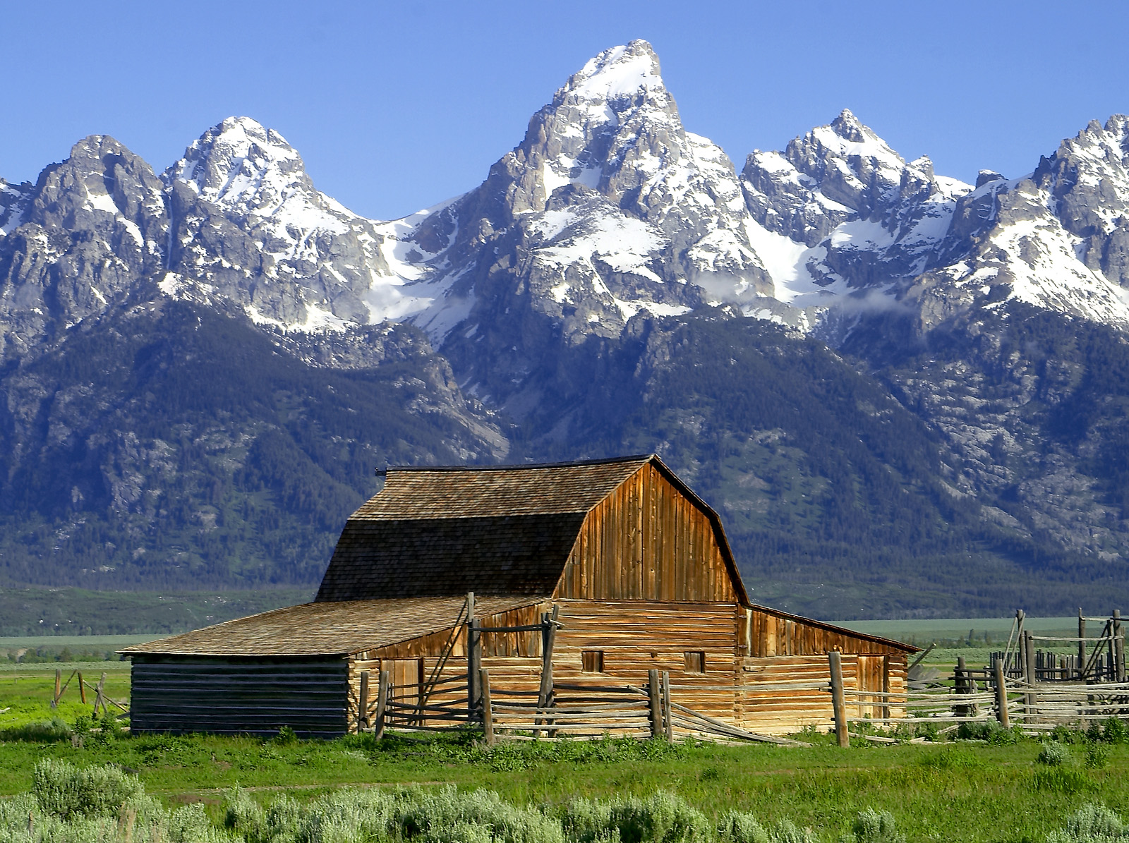 The John Moulton Barn on Mormon Row at the base of the Grand Tetons , Wyoming .